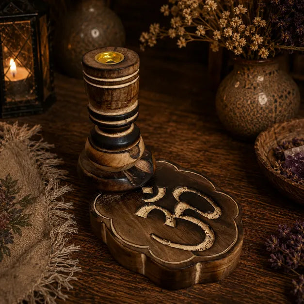 Wooden Om backflow incense burner with carved detailing and natural brown finish with dry flowers and rustic table cloth.