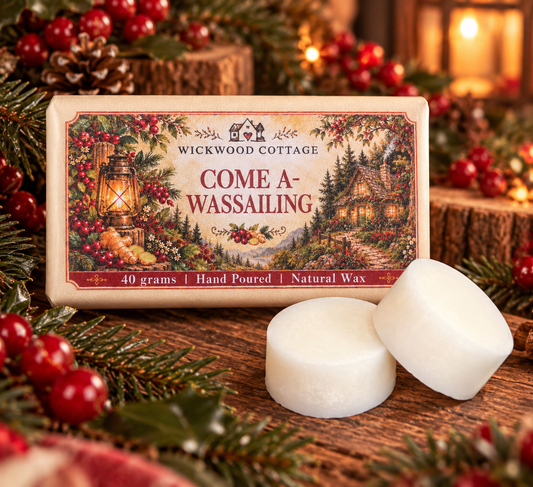 Wickwood Cottage Come A-Wassailing 40g hand-poured natural wax melts, featuring two chunky ivory wax discs beside festive woodland packaging on a rustic wooden table, surrounded by red berries, evergreen branches, pinecones and warm Christmas lighting.