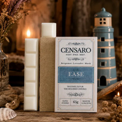 Censaro Ease scented wax melts in a kraft paper sleeve with the product box standing beside it on a rustic wooden surface. The box is cream and blue, and the wax melts are off-white.