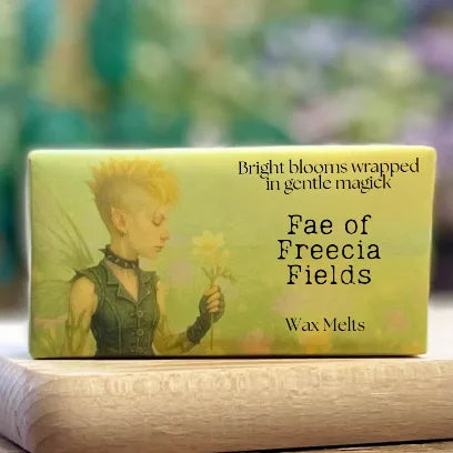 A close-up of the “Fae of Freecia Fields” wax melt packaging featuring a delicate faery illustration and soft floral tones.