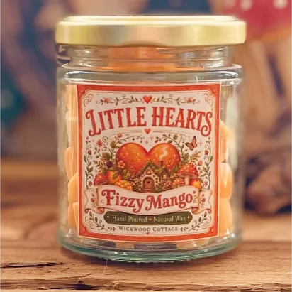 Close-up of a Little Hearts Fizzy Mango wax melt jar with a whimsical vintage-style label and orange heart-shaped wax melts inside.