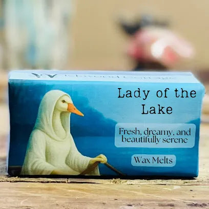 A close-up of the “Lady of the Lake” wax melt packaging with tranquil blue water tones.