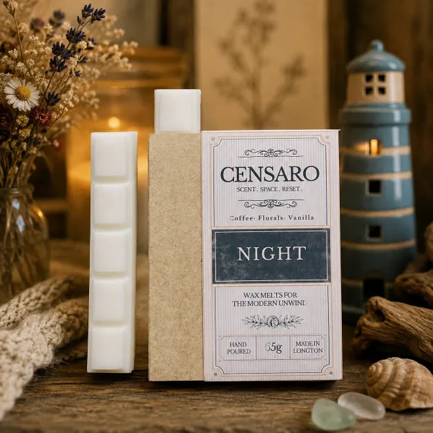 Censaro wax melts in a 'Night' scent, shown with two white wax melts in a white container, a beige wax melt stick in a kraft paper sleeve, and its product packaging box. The scene is styled on a rustic wooden table with dried flowers, a lighthouse figurine, and a knitted blanket.